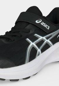Μαύρο αθλητικό παπούτσι Asics με λευκή σόλα και λογότυπο, με μαύρα κορδόνια και μαύρο λουράκι με βέλκρο σε απλό φωτεινό φόντο.
