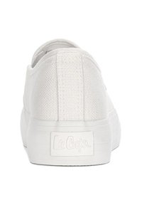 Białe płócienne trampki o gładkiej teksturze, płaskiej gumowej podeszwie i przeszyciu na pięcie. Zawierają markową metkę z tyłu.