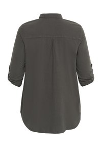 Chemise à manches longues vert foncé avec un col, manches à boutons retroussées et ourlet arrondi. Tissu lisse avec une texture subtile.