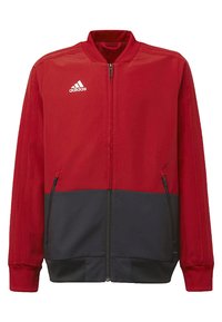 Red and navy zip-up jacket made of smooth fabric. Features a stand collar, side zip pockets, and three-stripe detail on sleeves.