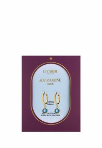 Goldene Creolen mit Aquamarin-Zirkonia-Steinen, präsentiert auf einer lila Karte mit goldenen Akzenten. Der Text gibt Material und Thema an.