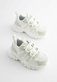 Baskets blanches et vert clair avec un dessus en mesh, un col rembourré et une semelle en caoutchouc texturé. Comprend des fermetures à lacets et à sangle.