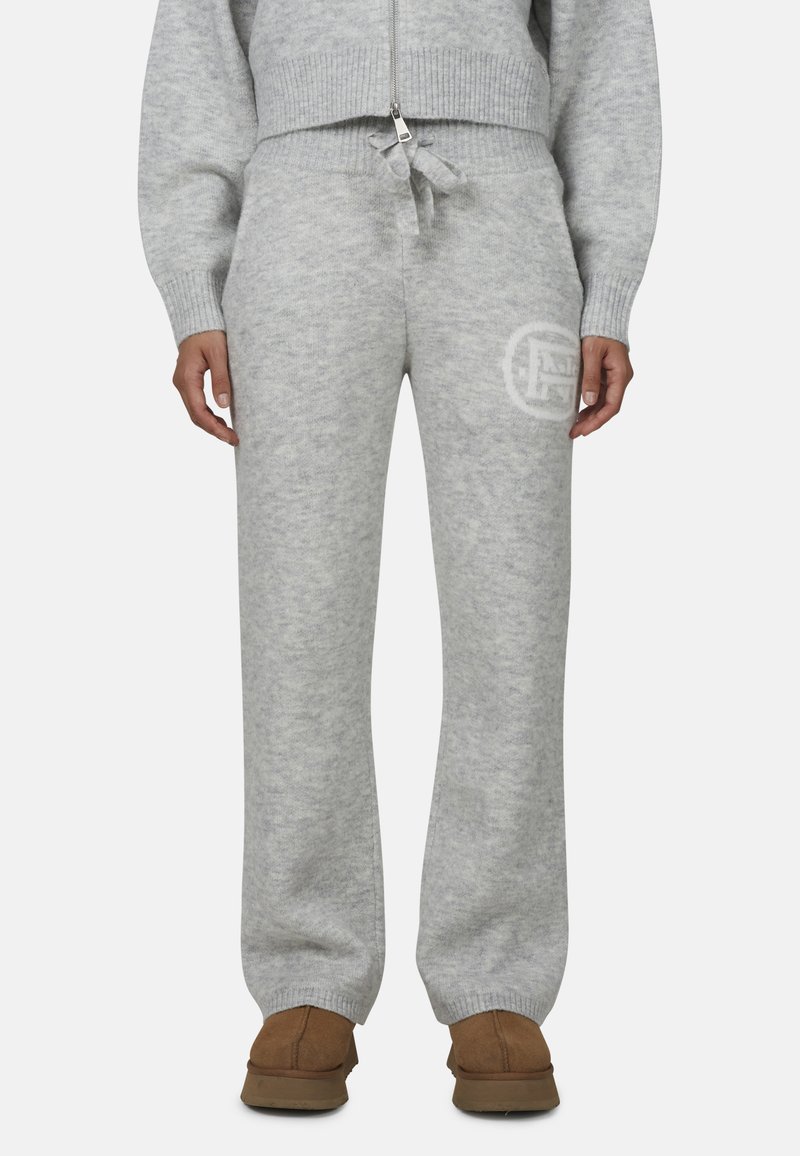 Jasnoszare, miękkie dresy wykonane z dzianiny o luźnym kroju, z elastycznym paskiem w talii i nadrukiem logo na lewym udzie.