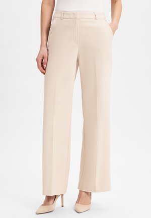 Beige wide-leg trousers made of smooth fabric, featuring side pockets and a tailored waistband, paired with nude high-heeled shoes.