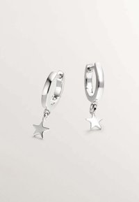 Pendientes de aro de plata con un acabado liso y un charm de estrella colgando de cada aro. El diseño es simple y elegante en su apariencia.