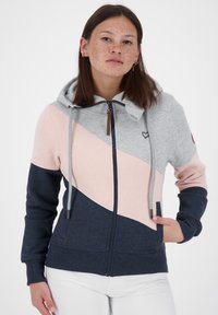 Felpa con cappuccio e zip, disponibile nei colori grigio, rosa e blu navy. Presenta blocchi di colore diagonali, cordini regolabili e tasche frontali.