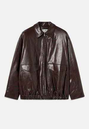 Veste en cuir marron avec fermeture éclair à l'avant, grandes poches poitrine et taille élastiquée. Dotée d'un col pointu et d'une texture lisse.