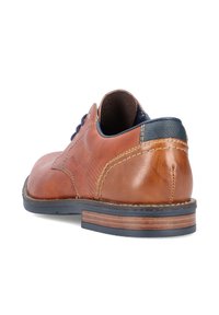 Chaussure en cuir marron avec une finition lisse, accents bleu marine et couture contrastante. Dotée d'un talon en bois empilé et d'une conception à bout rond.
