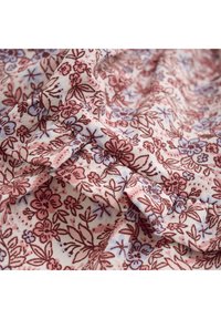 Blumenmusterstoff in Weiß, Rosa und Maroon. Mit verstreuten Blumen und Blättern, weicher Textur und leichtem Glanz.