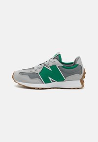 Zapatilla gris con acentos verdes, detalles blancos, superficie texturizada, puntera redonda, suela plana y diseño de cordones. Suela de goma con patrones de tracción.