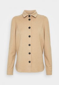 Giacca beige con bottoni, colletto, sette bottoni neri lungo la parte anteriore e maniche lunghe con spalle leggermente arruffate.