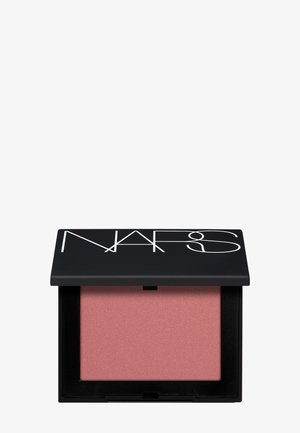 Boîtier compact noir ouvert avec le logo NARS contenant un blush poudre rose sur fond blanc uni.