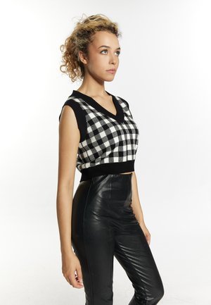 Schwarz-weißer kariert ärmelloser Crop-Top mit V-Ausschnitt, kombiniert mit hoch taillierten schwarzen Lederhosen. Glatte Textur und figurbetontes Design.