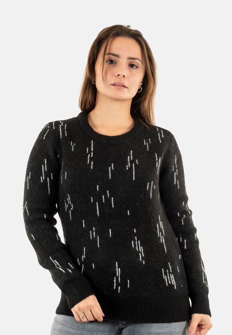 Suéter negro con patrón blanco, hecho de lana suave. Presenta un escote redondo y puños y dobladillo acanalados. Corte relajado.