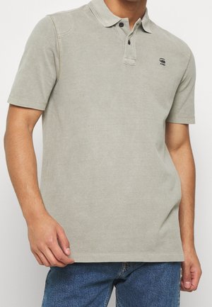 Polo shirt grigio chiaro realizzato in morbido cotone, con colletto classico, patta con due bottoni e maniche corte. Include logo sul petto.
