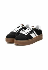 Zapatillas de ante negras con franjas y cordones blancos, que cuentan con una suela de goma y una plataforma de color marrón claro contrastante. Construcción duradera y diseño clásico.