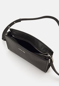 Borsa a tracolla in pelle nera con forma rettangolare, superficie testurizzata, cinturino singolo regolabile e dettaglio zip in argento.