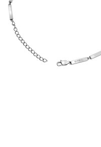 Pulsera de metal plateado con eslabones alargados, una extensión de cadena circular y un cierre con el nombre de la marca "BREIL". Acabado liso y brillante.
