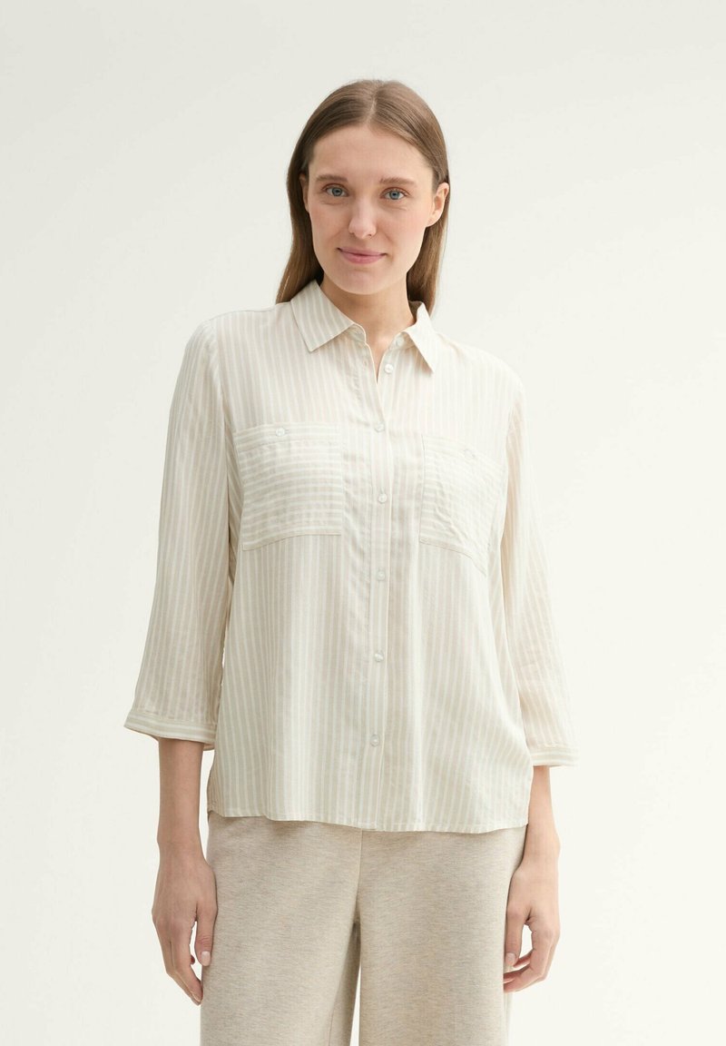 Light beige striped button-up shirt with three-quarter sleeves, featuring two chest pockets and a soft, smooth texture.