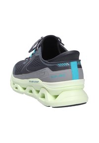 Graue Sneaker mit Obermaterial aus Mesh, reflektierenden Akzenten und einer leicht grünen, gepolsterten Sohle. Mit den Marken "SLIP-INS" und "GLIDE-STEP".