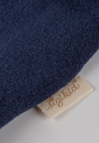 Navy blue soft fabric with a textured surface, featuring a cream tag with "sigikid" printed in brown script.