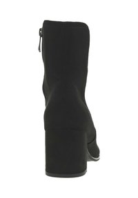 Botte noire à la cheville avec un bout arrondi, tige en tissu lisse et talon épais. Présente une fermeture éclair sur le côté et une semelle robuste.