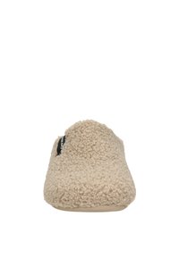 Beige slipper met een fuzzy textuur, gesloten puntontwerp en een zwart label aan de zijkant. Zacht stofmateriaal voor comfort.