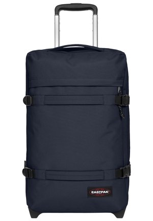 Navy blue wheeled duffel bag with multiple straps, fabric handle, and Eastpak logo. Smooth material, rectangular shape, and sturdy wheels.