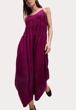 Magenta, sleeveless maxi dress with gathered details, adjustable straps, and a loose fit. Soft, textured fabric flows to the ankles.