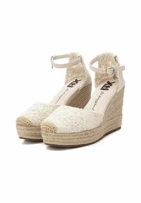 Sandalias de cuña beige con tejido trenzado y patrón texturizado. Tira en el tobillo con herrajes plateados, suela envuelta en yute y diseño de punta cerrada.