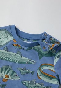 Blaues Baumwollhemd mit langen Ärmeln, das ein Fischmuster in Grün und Orange zeigt, mit Druckknöpfen an der Schulter für ein einfaches Anziehen.