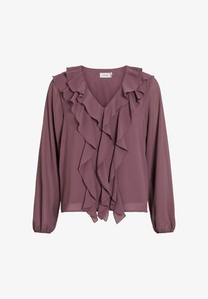 Šviesiai purpurinė palaidinė iš lengvos medžiagos, su V formos iškirpte, ilgomis rankovėmis ir raukiniais priekyje. Lašėjo siluetas su elastinėmis rankogaliais.