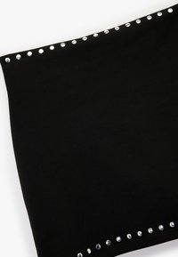 Sort stoftop med en glat tekstur, prydet med metalnitter langs den øverste kant for accent. Enkel, tætsiddende design.