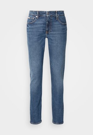 Blue denim jeans with a slim fit, featuring a button closure, five pockets, and subtle stitching details. Fabric has a smooth, soft texture.