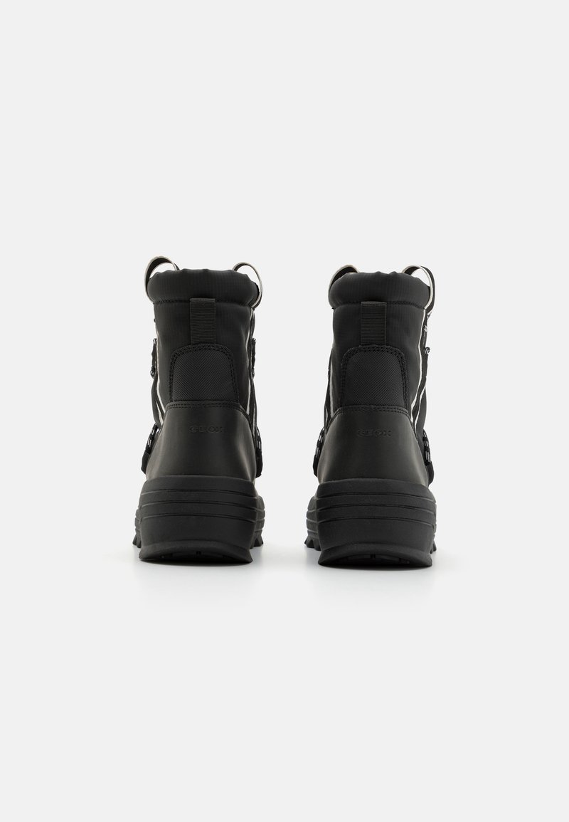 Czarne wodoodporne buty z teksturowanego materiału syntetycznego, z wysokim kołnierzem, regulowanymi paskami i solidnymi gumowymi podeszwami.