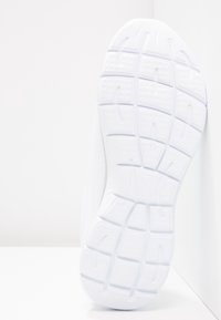 Vit löparskosula med texturerat mönster, tillverkad av gummi. Slät yta med definierade spår för grepp.