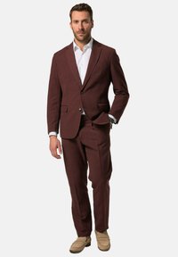 Completo in lino bordeaux con due bottoni, rever a chiocciola e tasche laterali. Abbinato a una camicia bianca e mocassini beige chiaro.