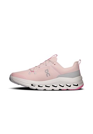 Une chaussure de course rose pâle avec des détails gris, des lacets roses et une épaisse semelle blanche dotée d’ouvertures ovales, présentée de profil sur fond blanc.