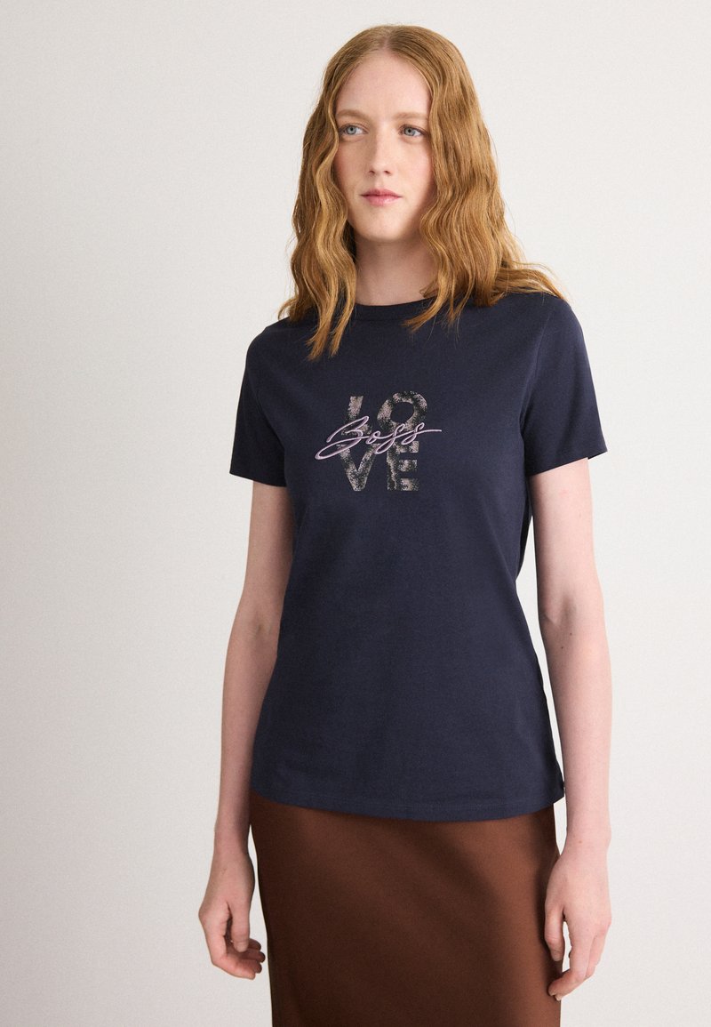 Navy blue cotton t-shirt with short sleeves, featuring metallic graphic text "love" and "selfs" in various fonts at the center front.