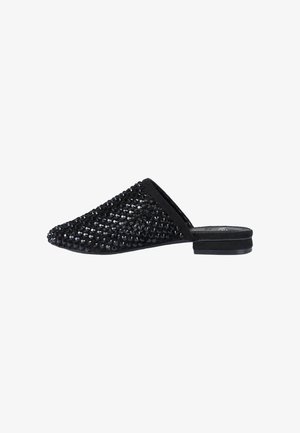 Scarpa mule nera senza lacci con punta appuntita, decorata con piccole perline nere lucide e tacco piatto su sfondo bianco.