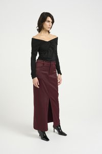 Svart off-shoulder topp med vridd foran, parret med en burgunder slim-fit maxiskjørt med frontslitt, iført glinsende svarte høyhælte støvler.