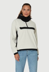 Kurtka typu pullover w odcieniu kremowym z czarnymi akcentami, z zamkiem z przodu, wysokim kołnierzem oraz detalem z logo. Wykonana z miękkiego, teksturowanego materiału.