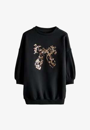 Schwarzes Langarm-Sweatshirt mit geripptem Kragen und Bündchen, das ein großes glänzendes Paillettenschleifen-Design auf der Vorderseite zeigt.