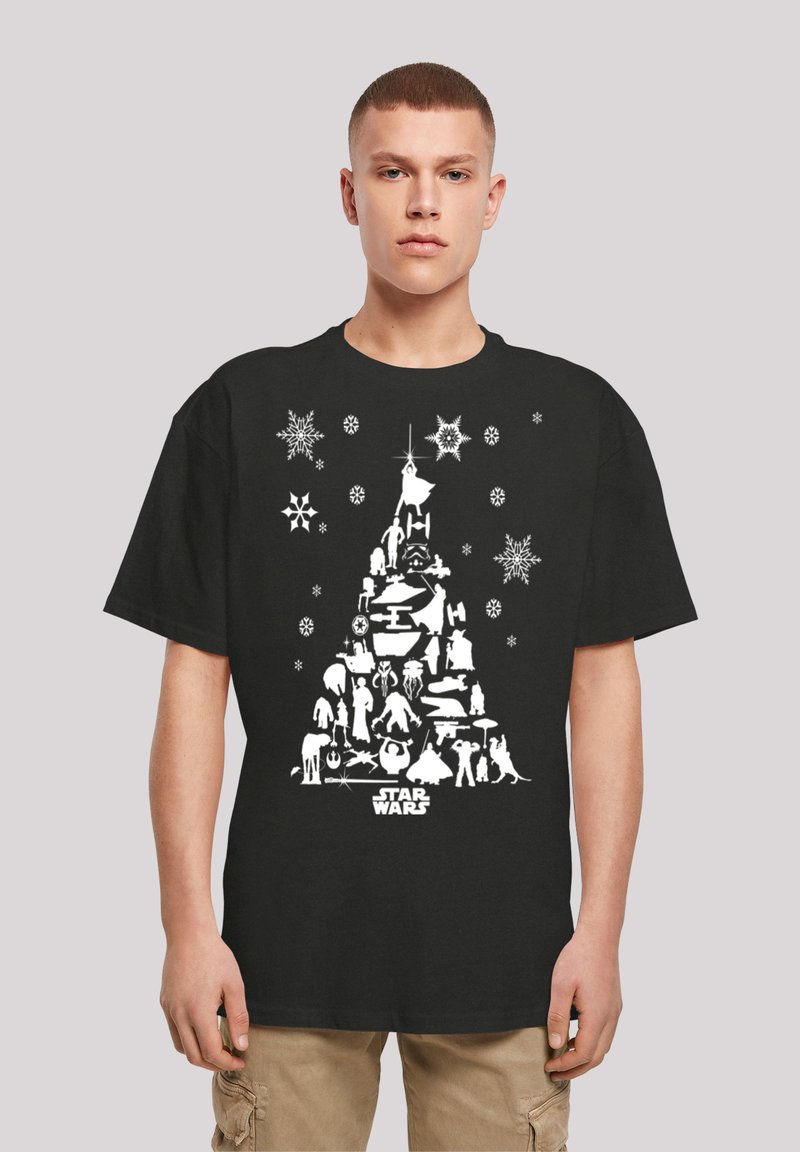 Melnā T-kreklā ir balts grafisks dizains ar Ziemassvētku eglīti, kas veidota no Star Wars varoņiem, ar sniegpārslām un "Star Wars" tekstu apakšā.