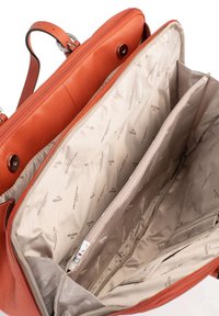 Borsa in pelle arancione con una texture liscia, dotata di chiusura con zip e numerosi scomparti foderati con tessuto beige stampato con loghi.