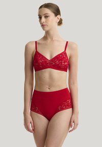 Rote Spitzen-Bralette mit verstellbaren Trägern und einem passenden hochgeschnittenen Slip mit Spitzenakzenten an den Seiten. Glatte Textur durchgehend.
