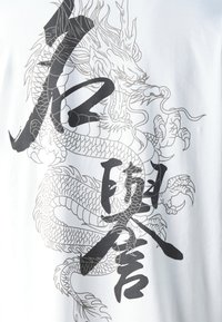 White t-shirt featuring a large black dragon graphic with detailed scales and bold lettering. The design has a smooth texture and minimalist style.