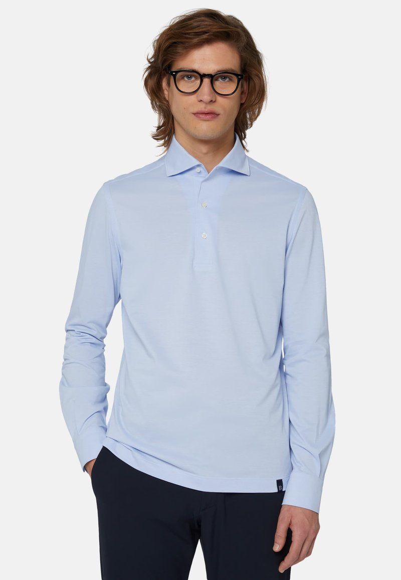 Svetlo modra dolga majica s polo ovratnikom, s tremi gumbi in majhnim logotipom na robu. Gladek, mehak tekstil.
