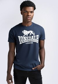 Mornarsko plava pamučna majica s bijelim grafičkim prikazom lava i tekstom "LONSDALE LONDON". Kratki rukavi i dizajn s okruglim izrezom.