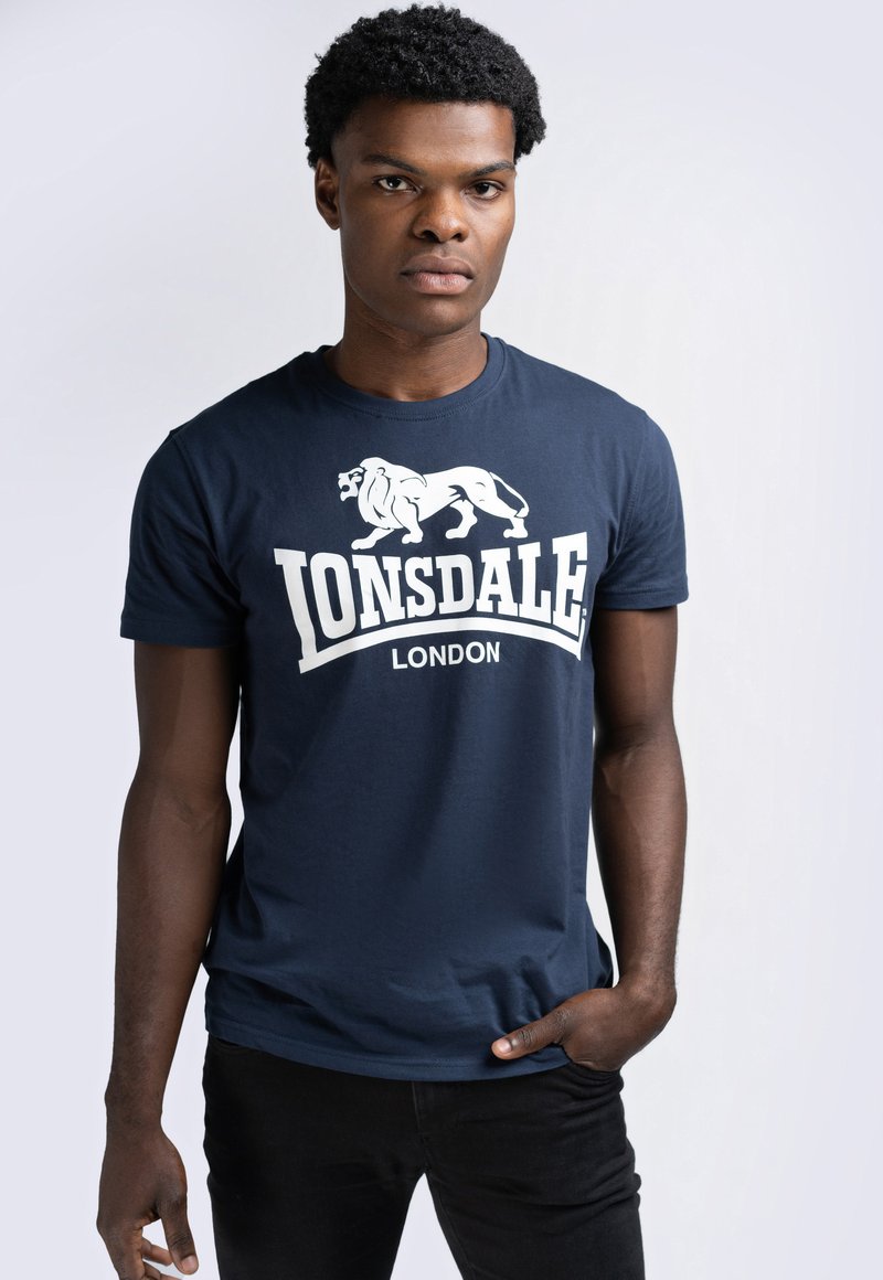 Mornarsko plava pamučna majica s bijelim grafičkim prikazom lava i tekstom "LONSDALE LONDON". Kratki rukavi i dizajn s okruglim izrezom.